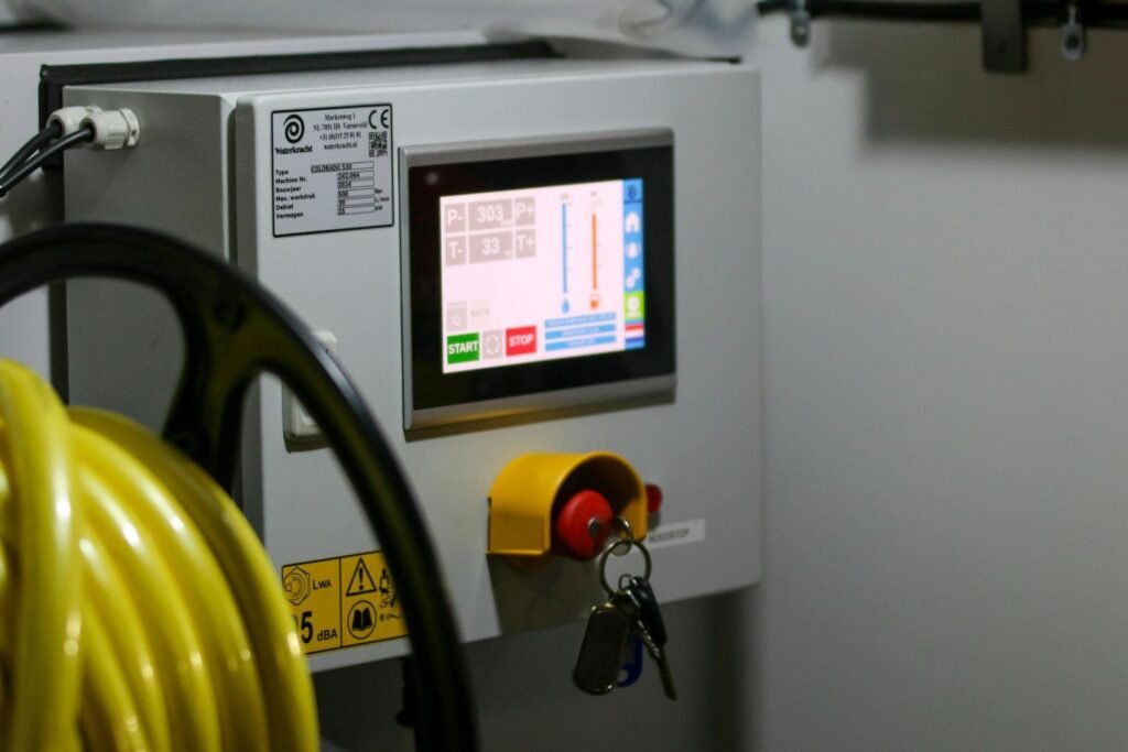 Close-up of an industrial machine control panel with touchscreen and emergency stop button