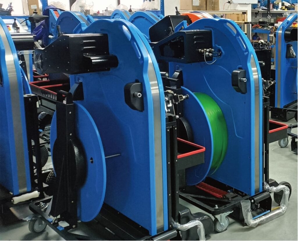 Side view of a blue pallet strapping machine in the workshop
