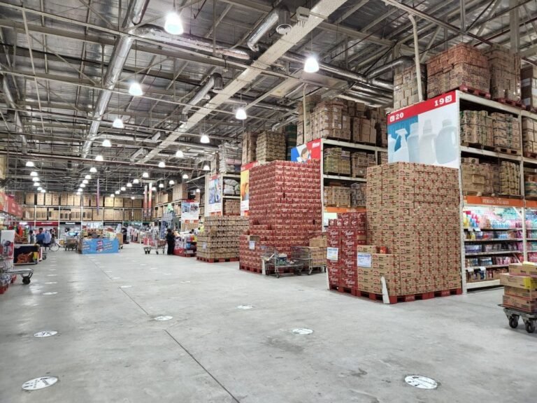 Bulk warehouse storage area with stacked palletized cartons for strapping and distribution