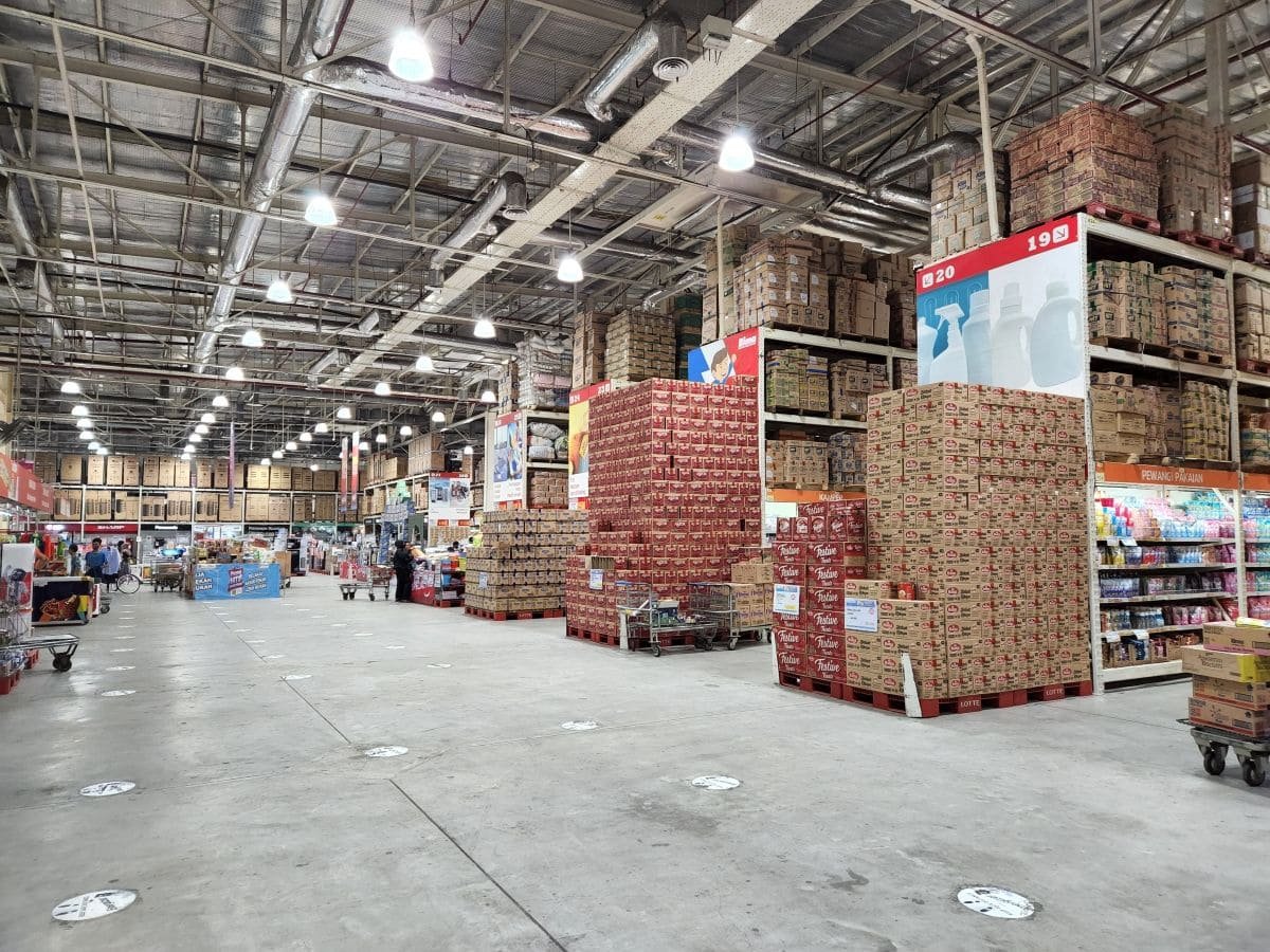 Área de almacenamiento a granel con cajas paletizadas apiladas para flejado y distribución.