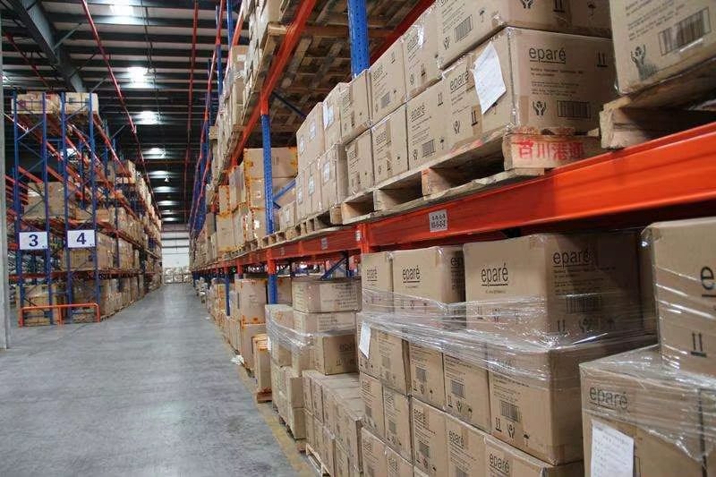 Entrepôt industriel avec cartons empilés et stocks palettisés pour les opérations d'emballage et de logistique