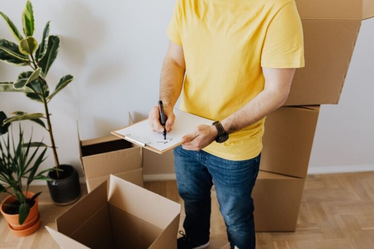 Un ouvrier consigne ses observations lors d'un test sur un échantillon de carton dans un entrepôt.