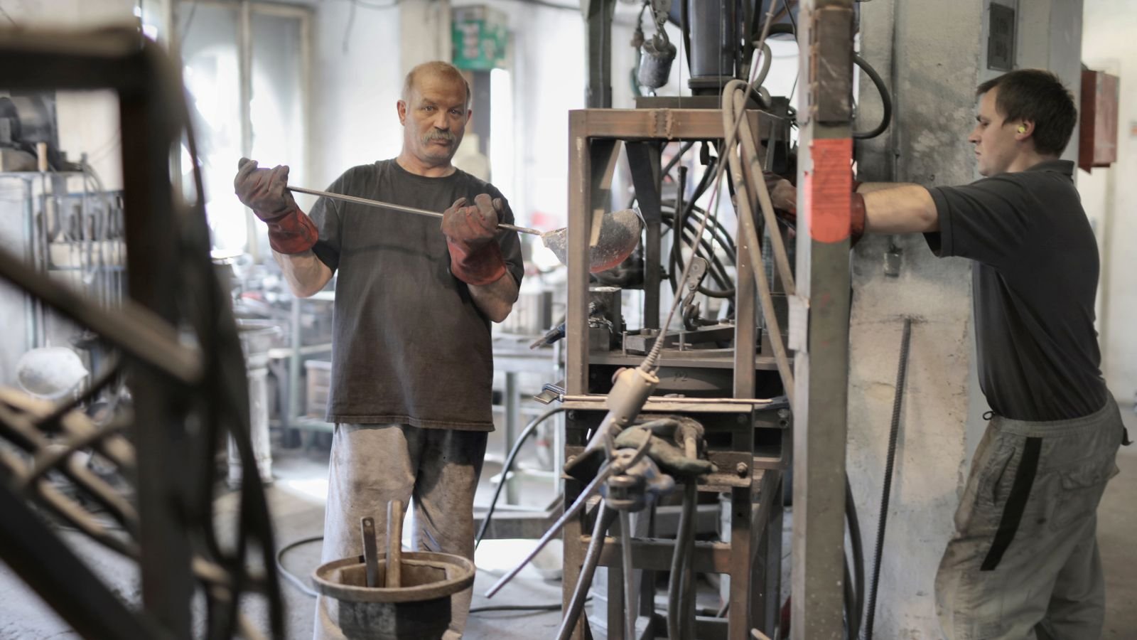 Equipe de manutenção realizando serviços em equipamentos industriais em uma oficina.