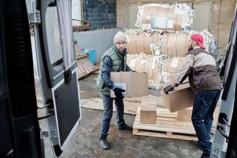 Arbeiter verladen Kartons zum Versand und veranschaulichen so die Anwendungsmöglichkeiten von Schutzschaumverpackungen.