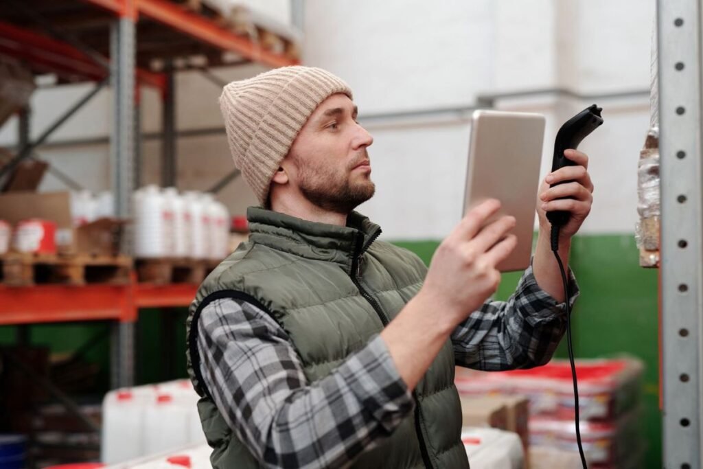 Warehouse worker scanning inventory with a handheld barcode scanner and tablet