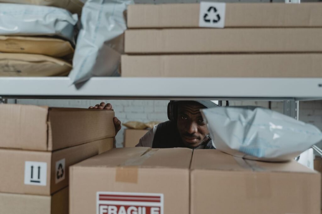 Warehouse worker reviewing boxes and packaging materials on storage shelves
