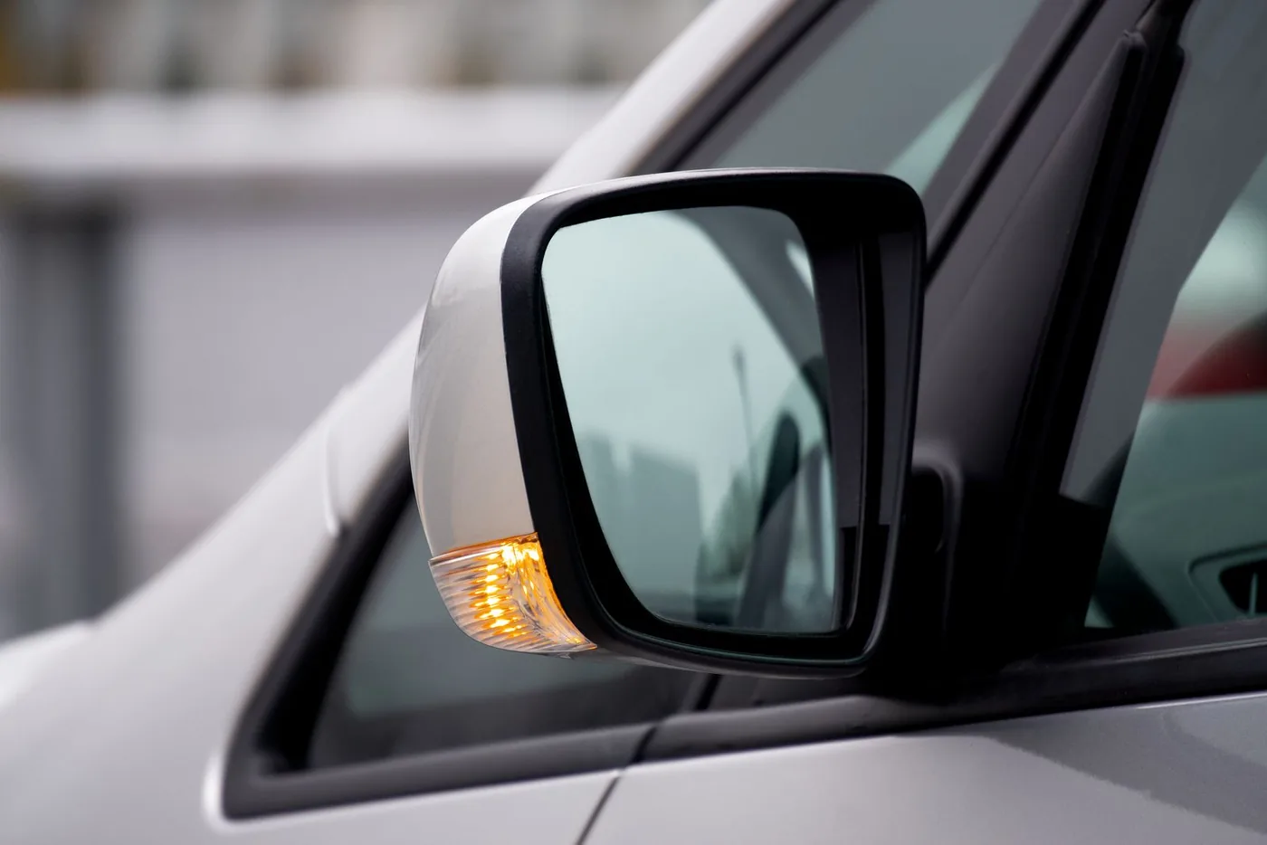 Automotive side mirror with glass, painted housing and indicator lens