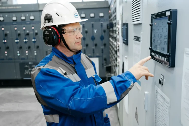 Technician testing control panel functions during a shrink wrap machine factory acceptance test