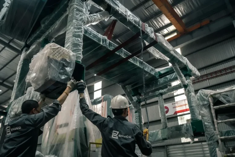 Installation team positioning industrial equipment for a shrink wrap machine project