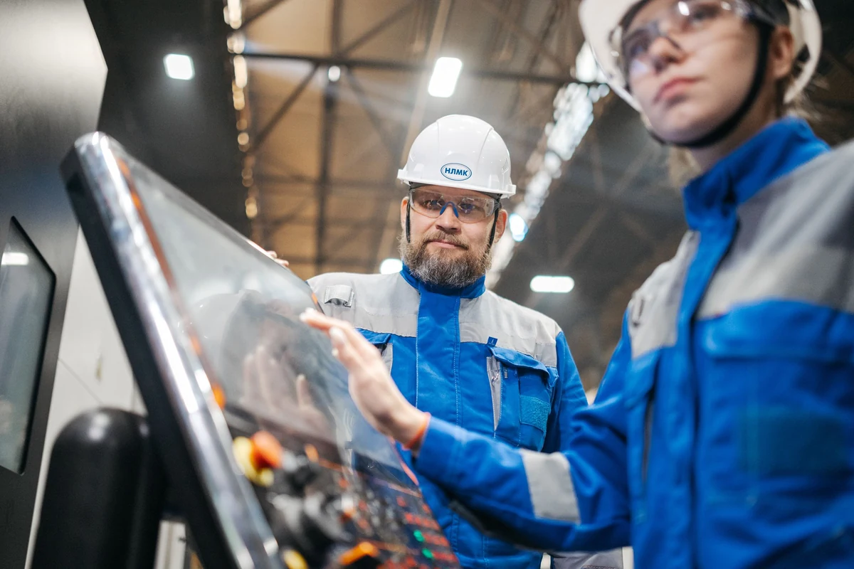 Operators checking the control interface of an automated shrink wrapping production line