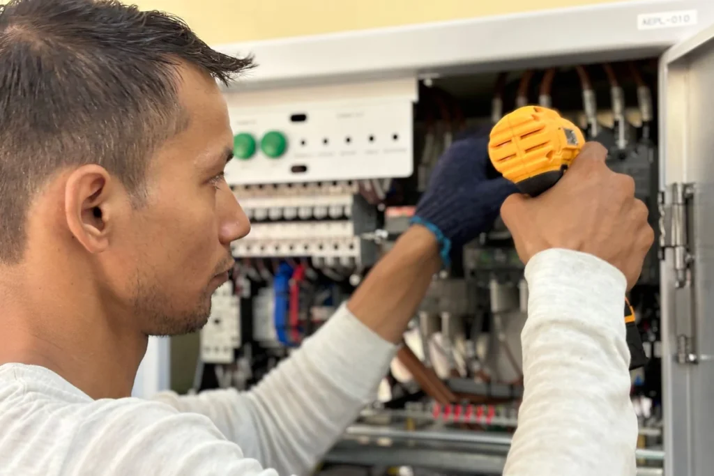 Technicien ajustant les commandes de la machine lors de la maintenance de la machine d'emballage sous film rétractable