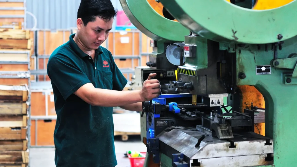Factory operator adjusting industrial machinery during production