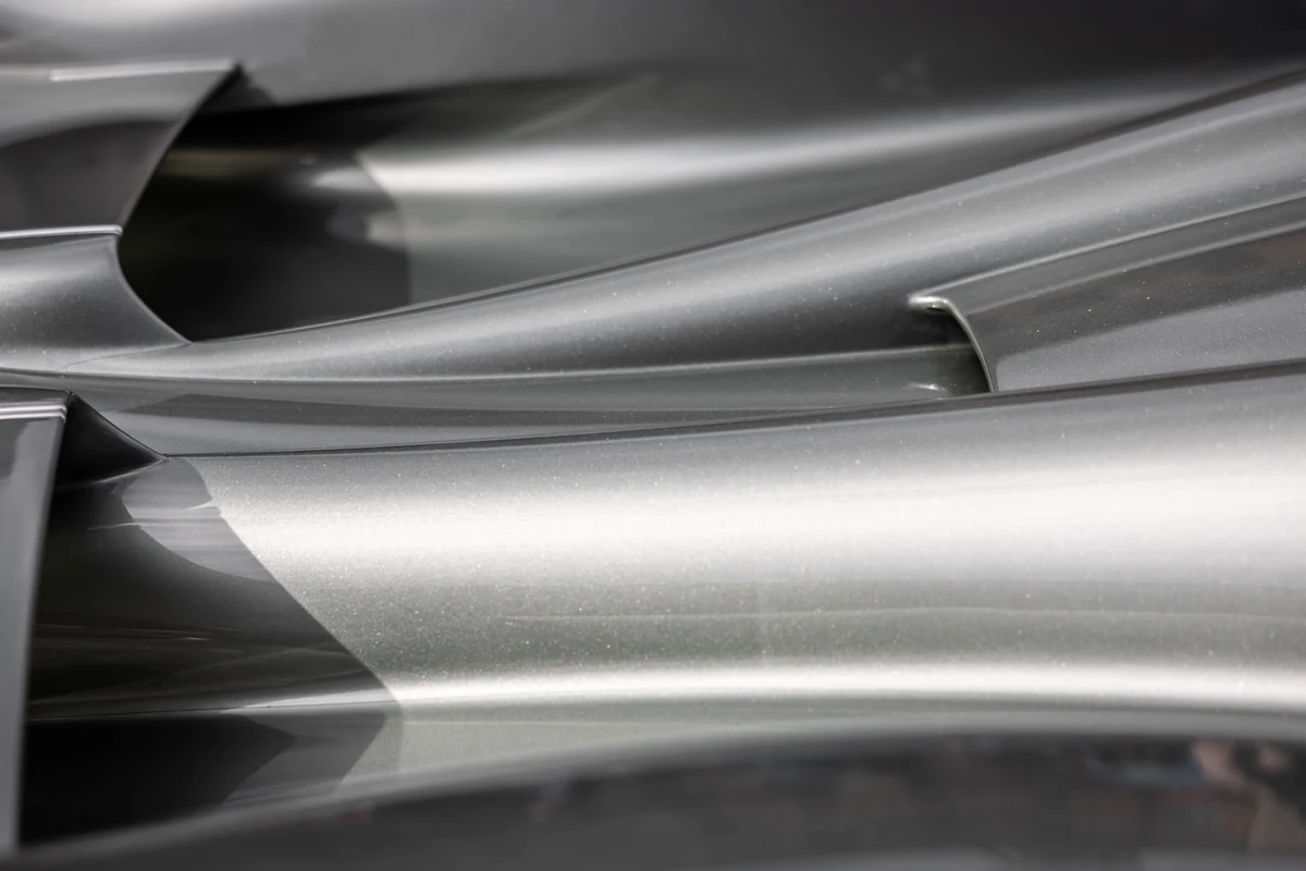 Close-up of curved metallic surfaces with smooth edges and reflected light.