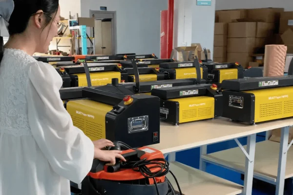 Operator inspecting yellow and black automatic bagging machines in the production area