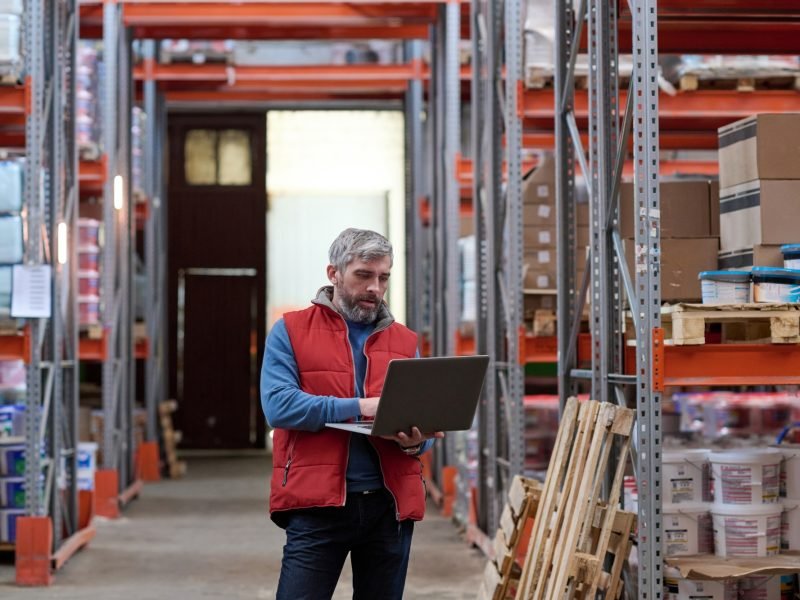 Distributor using laptop at warehouse Distributor using laptop at warehouse