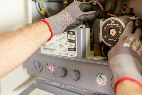 Técnico revisando los controles internos y realizando el mantenimiento de una máquina flejadora.
